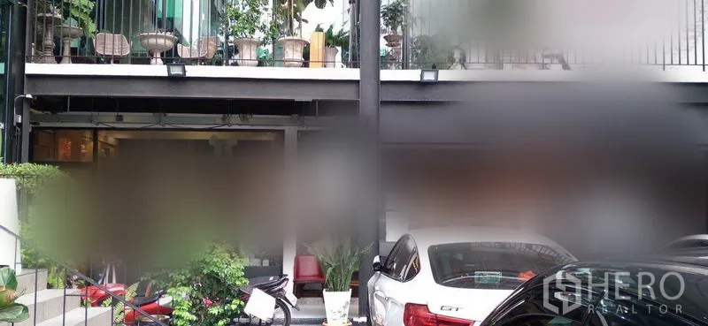 พื้นที่ขายปลีก ให้เช่าในWatthana, Bangkok - อาคารพาณิชย์สองชั้น ระเบียงมีต้นไม้ และที่จอดรถชั้นล่างมีรถจอด