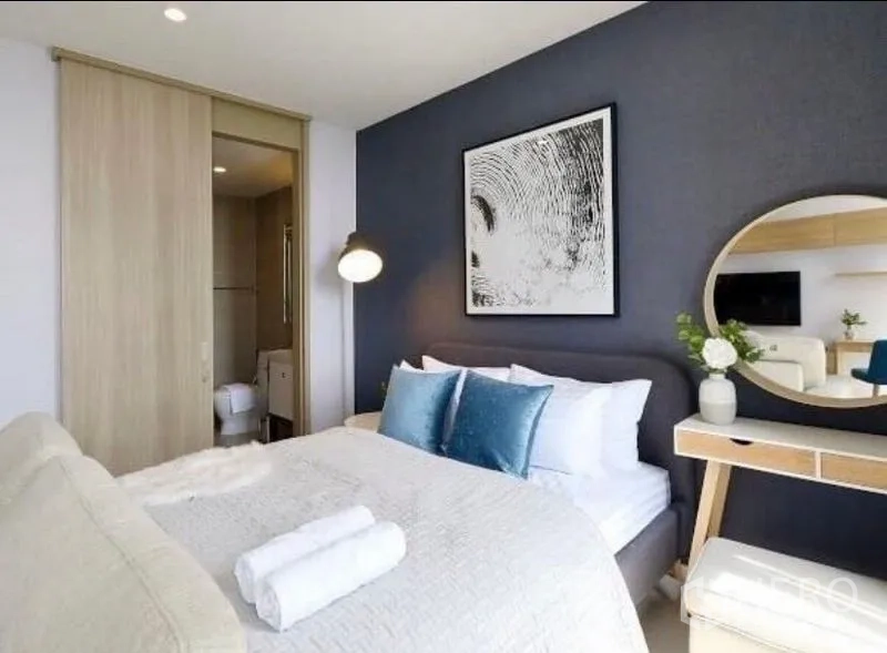 คอนโด ให้เช่าในPathum Wan, Bangkok - ห้องนอนมีโทนสีน้ำเงิน มีกระจกโต๊ะเครื่องแป้งทรงกลม และทางเข้าห้องน้ำ