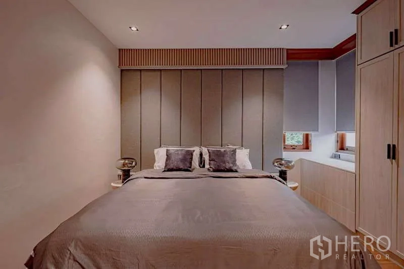 บ้าน ให้เช่าหรือขายในPhra Khanong, Bangkok - ห้องนอนแขกอบอุ่น หัวเตียงบุผ้า โต๊ะข้าง และตู้บิวท์อิน