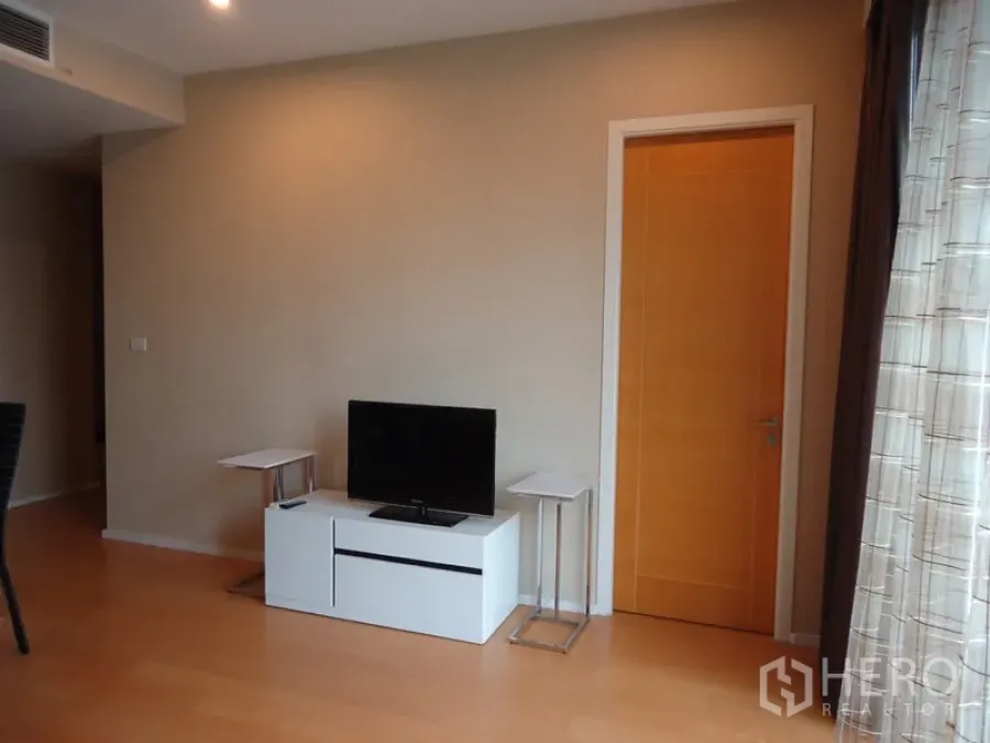 คอนโด ให้เช่าในChatuchak, Bangkok - มุมนั่งเล่นสว่าง พร้อมชั้นวางทีวี โต๊ะข้าง และพื้นไม้โทนอ่อน