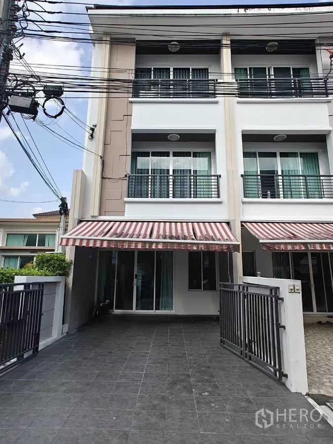 联排别墅 出租或出售在Lat Phrao, Bangkok - 三层现代联排别墅外观，带可上锁车道与条纹遮阳篷，位于拉抛区。