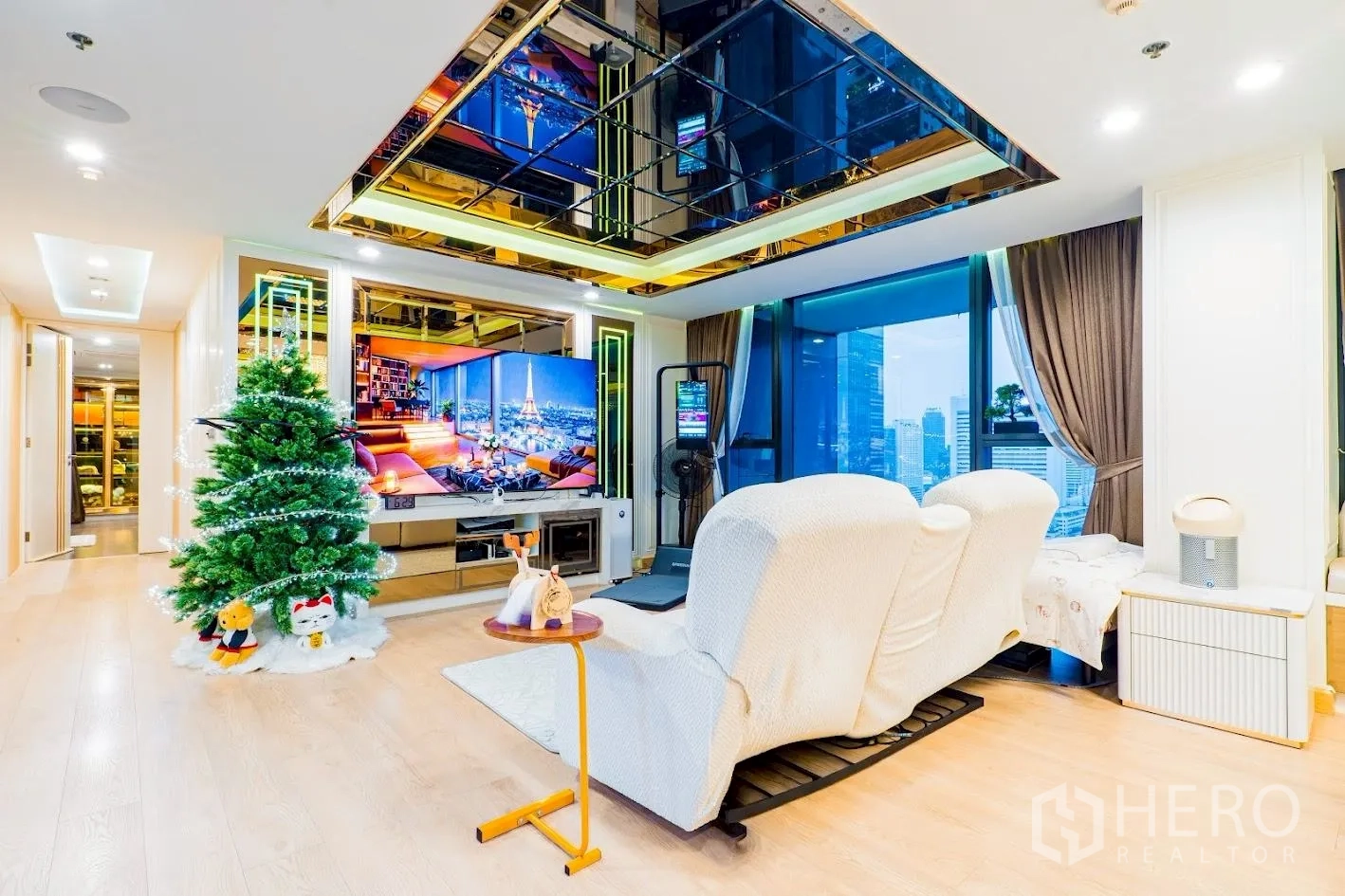 คอนโด for sale in Sathon, Bangkok - มุมนั่งเล่นเก้าอี้รีไคลเนอร์และผนังทีวีพร้อมวิวเมืองกว้าง