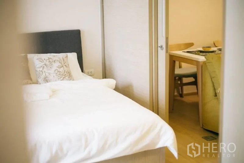 คอนโด ขายในWatthana, Bangkok - ห้องนอนปูผ้าปูที่นอนสีขาว มองจากประตูเชื่อมต่อสู่ส่วนรับประทานอาหาร.