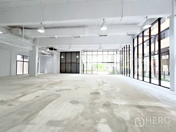 Office Space for rent in Watthana, Bangkok - Spacious bare-shell office interior with high ceilings, pendant lights, and full-height windows.