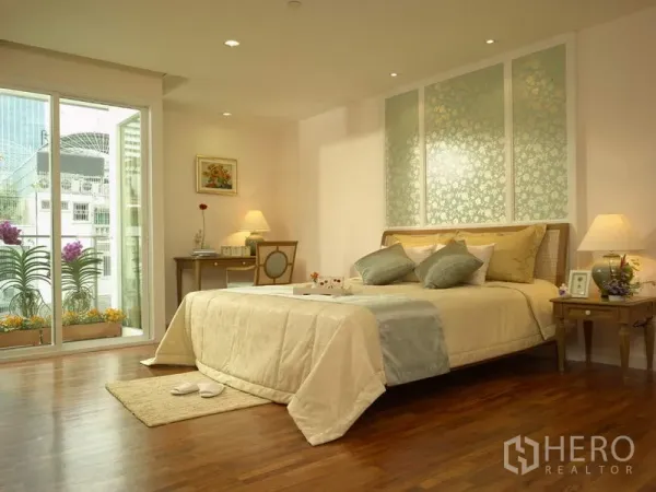 Apartment for rent in Bang Rak, Bangkok - Spacious master bedroom with king bed, wood floors and balcony showing city view and potted orchids.