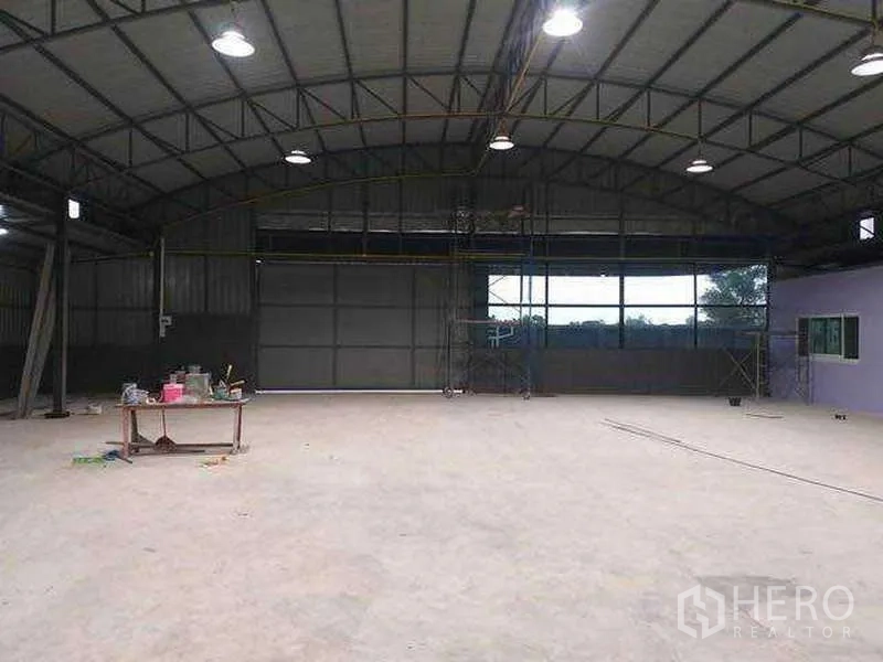 货栈 出租在Khlong Sam Wa, Bangkok - 仓库内部开阔无柱，高拱钢架顶、采光窗与明亮工矿灯。
