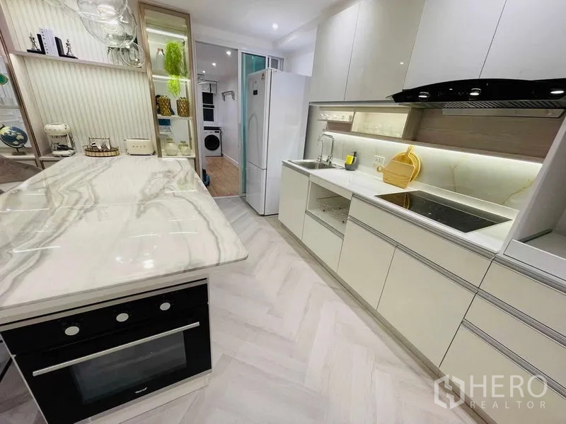 Condominium for sale in Yan Nawa, Bangkok - Contemporary kitchen with marble island, built-in oven, and induction cooktop.