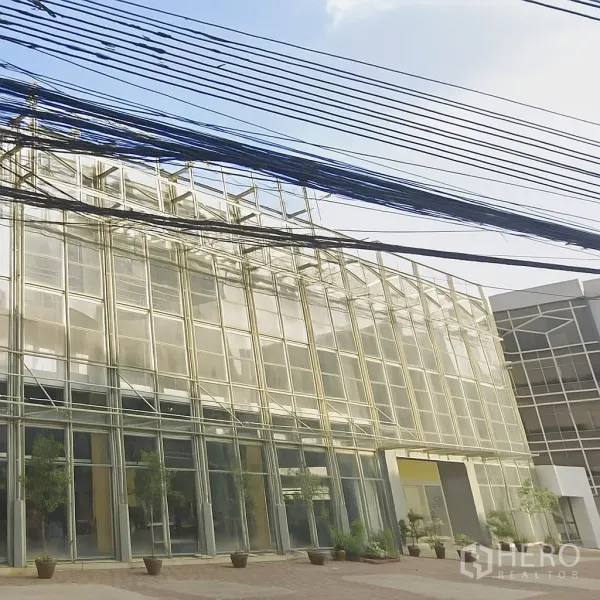 Office Space for rent in Mueang Nonthaburi, Nonthaburi - Modern glass-front office building exterior in Mueang Nonthaburi with wide forecourt and planters.