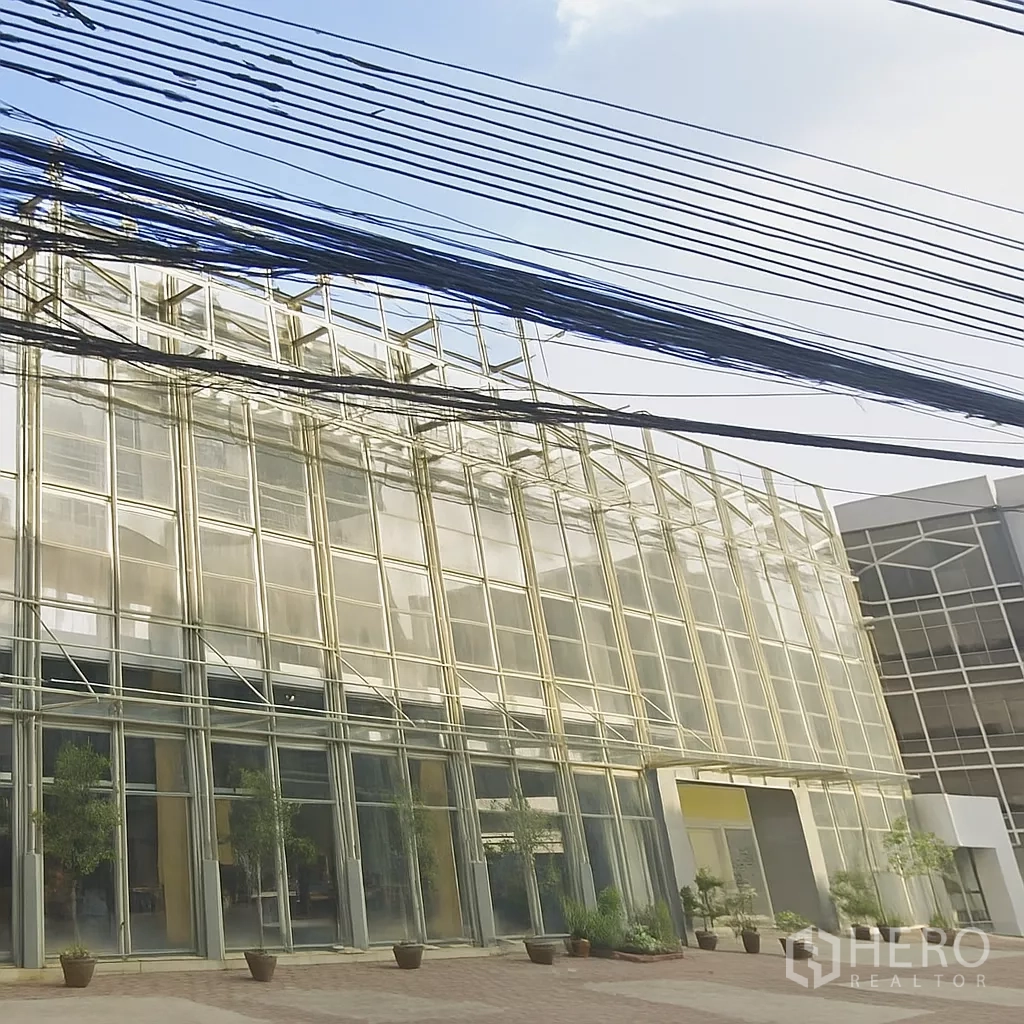 Office Space for rent in Mueang Nonthaburi, Nonthaburi - Modern glass-front office building exterior in Mueang Nonthaburi with wide forecourt and planters.