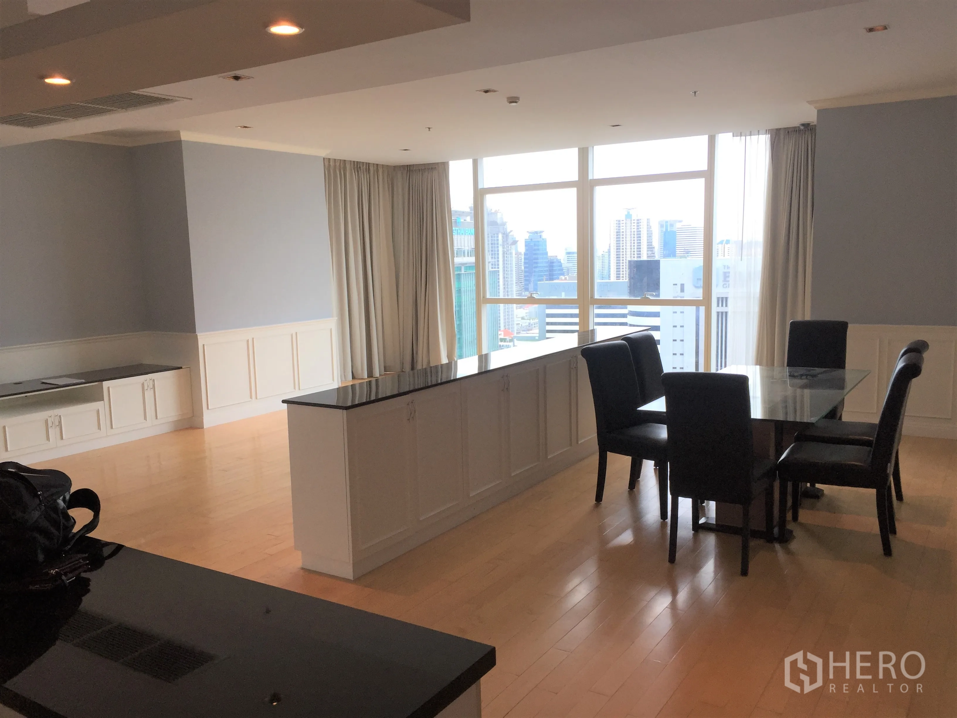 Condominium for rent in Pathum Wan, Bangkok - Spacious living–dining room with city views and recessed lighting.