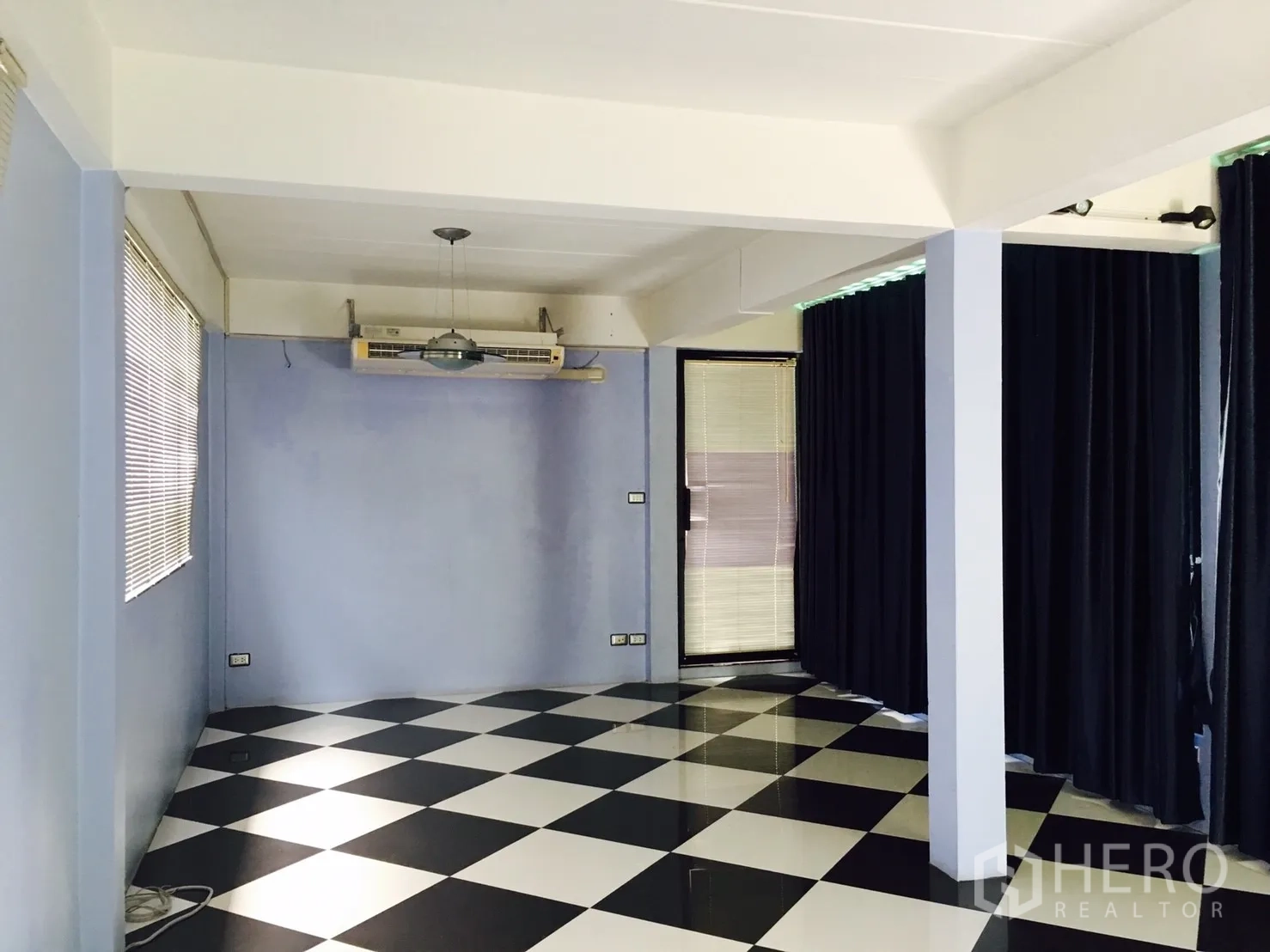 Detached House for rent in Wang Thonglang, Bangkok - Versatile room with blue walls and black-and-white checkered floor with curtained windows.