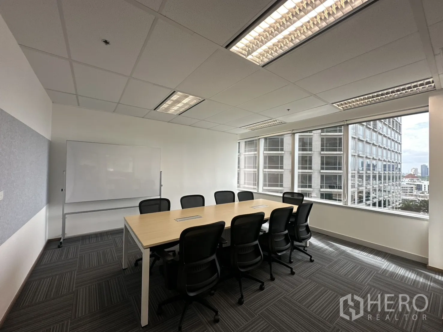 办公室 for rent in Pathum Wan, Bangkok - 明亮的会议室，长桌、多把座椅、白板与城市景观窗户。