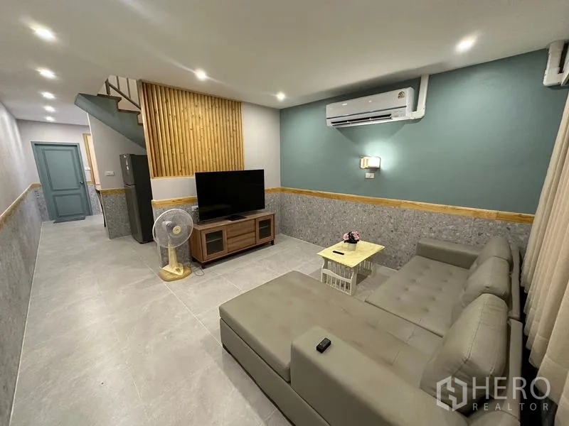 ทาวน์เฮาส์ ให้เช่าในPhra Khanong, Bangkok - พื้นที่รับรองแบบเปิด มองเห็นผนังทีวี บันได และทางเดินไปครัว