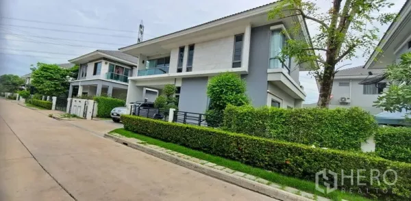 บ้าน ให้เช่าในLat Krabang, Bangkok - บ้านเดี่ยวสองชั้นสไตล์โมเดิร์นพร้อมรั้วพุ่มไม้ บรรยากาศถนนเงียบสงบในลาดกระบัง