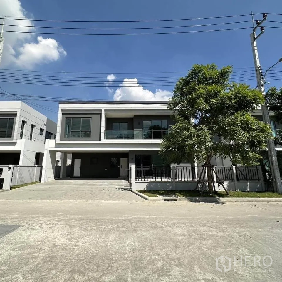 บ้านเดี่ยว for rent or sale in Bang Phli, Samut Prakan - ด้านหน้าบ้านสองชั้นสมัยใหม่ มีระเบียงกระจกและที่จอดรถในร่ม