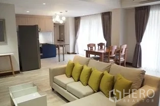 Condominium for rent in Pathum Wan, Bangkok - Open living area facing kitchen and dining table over warm wood flooring.