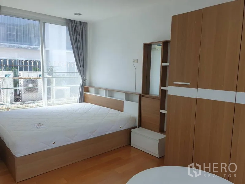 Detached House for rent in Khlong Toei, Bangkok - Second bedroom with double bed, wardrobe and sliding door to a balcony.