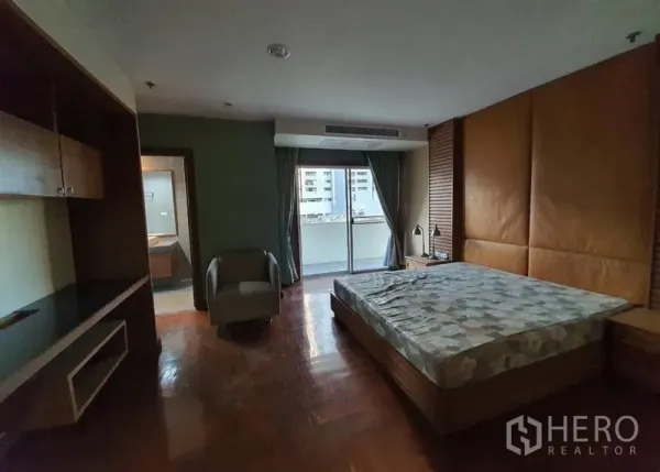 คอนโด ให้เช่าในWatthana, Bangkok - ห้องนอนใหญ่ เตียงคิง ผนังหัวเตียงบุหนัง และประตูกระจกสไลด์ออกระเบียง