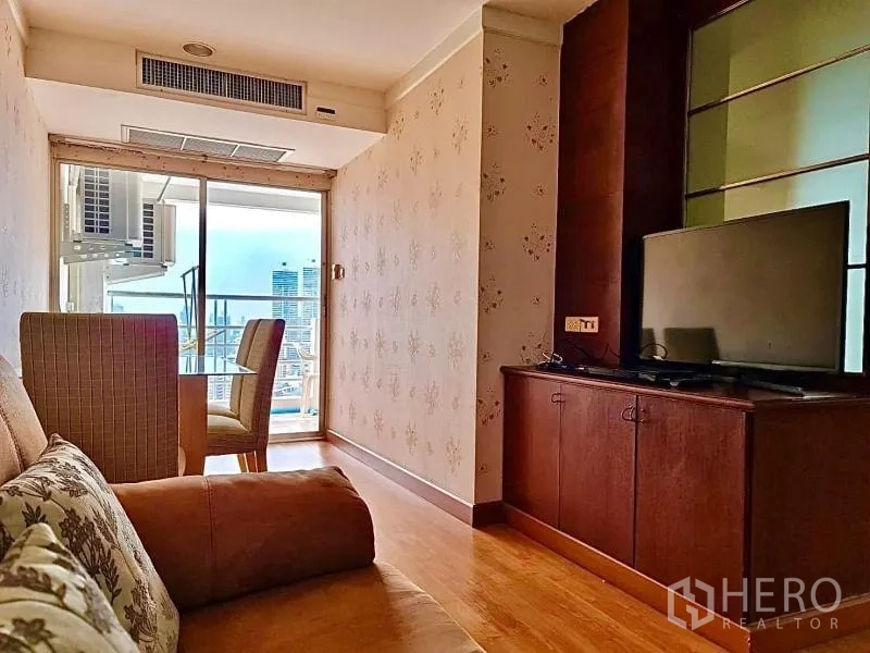 公寓 出租在Khlong Toei, Bangkok - 客厅通往阳台，配电视柜与餐桌椅。