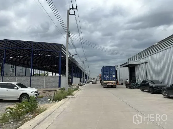 คลังสินค้า ให้เช่าในLat Krabang, Bangkok - ช่องทางระหว่างโกดังพร้อมเสาไฟและรถคอนเทนเนอร์ พื้นที่เข้าออกและกลับรถกว้างขวาง