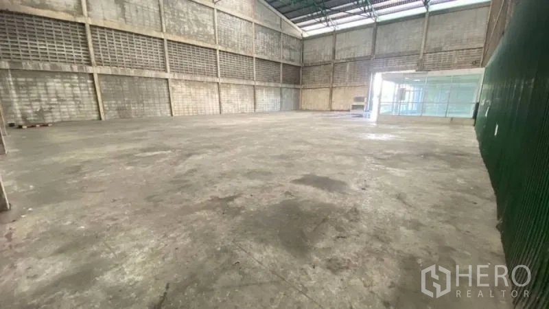 货栈 出租在Prawet, Bangkok - 通透开阔的工业空间，高跨度天花、通风砖墙与平整混凝土地面，便于装卸与存储。