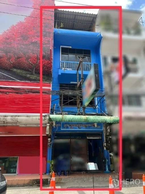 อาคารพาณิชย์ ให้เช่าหรือขายในBang Lamung, Chon Buri - มุมมองด้านหน้าของอาคารพาณิชย์ 3 ชั้นสีฟ้า มีระเบียงและโครงป้ายตั้งอยู่บนถนนการค้า