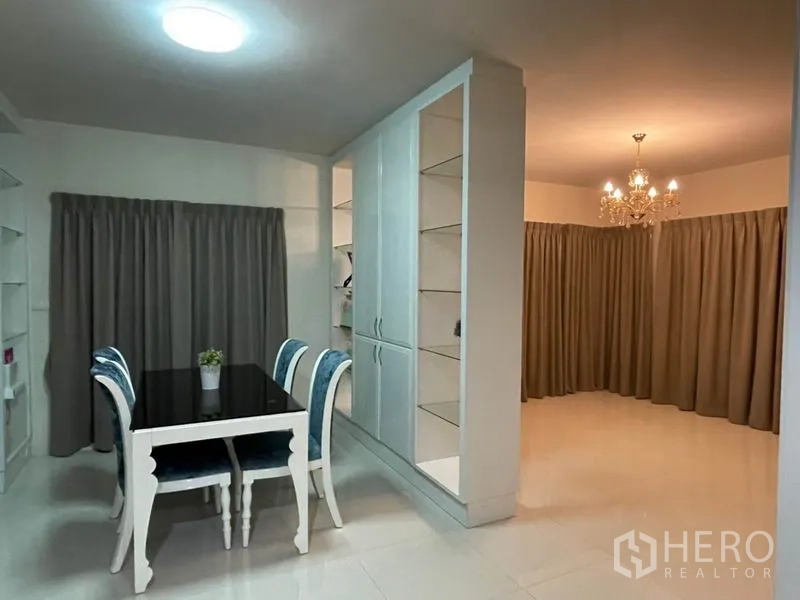 Detached House for sale in Khlong Toei, Bangkok - Cozy dining area with four-seat table beside tall white storage and shelves.