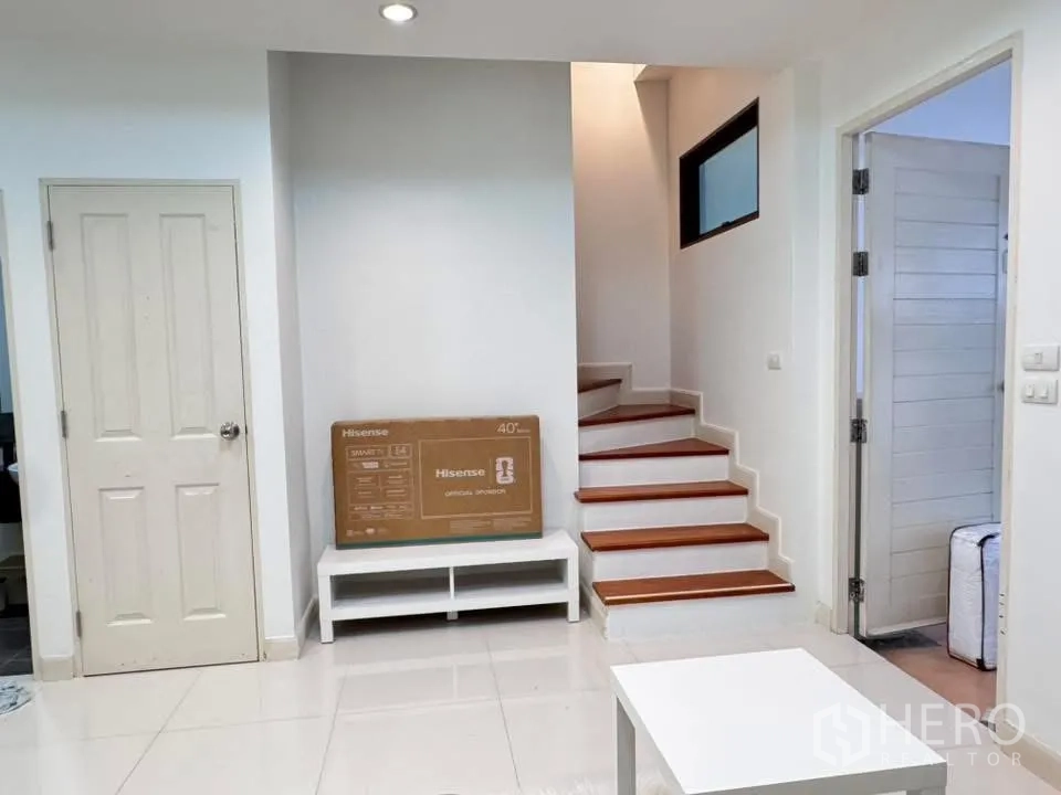 联排别墅 for rent in Phra Khanong, Bangkok - 一层走廊可见楼梯及与客厅相连的房门。