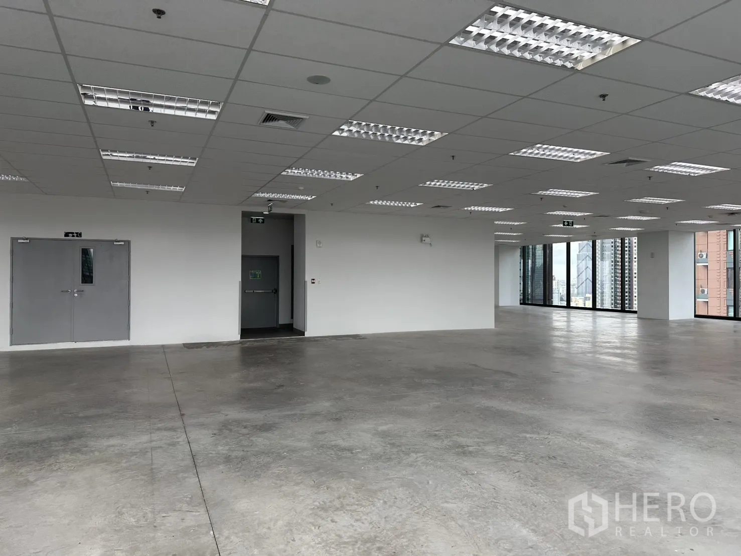 Office Space for rent in Ratchathewi, Bangkok - Emergency exit doors and bright fluorescent lights inside the vacant office.