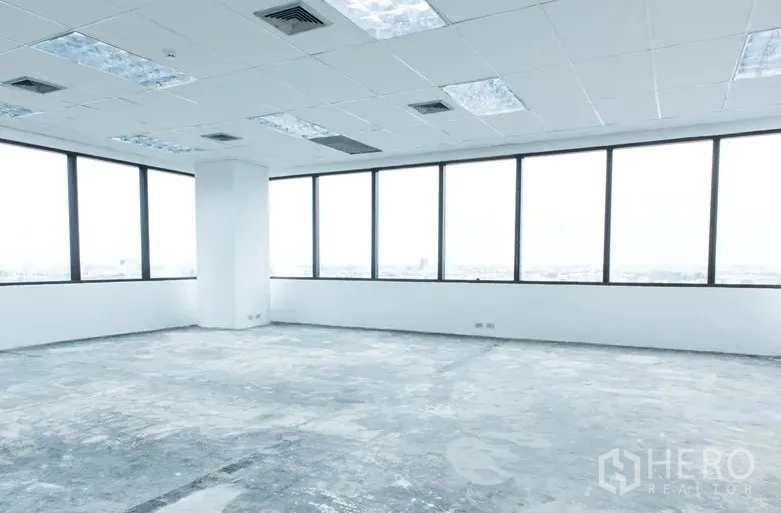 Office Space for rent in Bang Na, Bangkok - Open office space featuring panoramic windows, white walls, and a drop ceiling with air-conditioning vents and light panels.