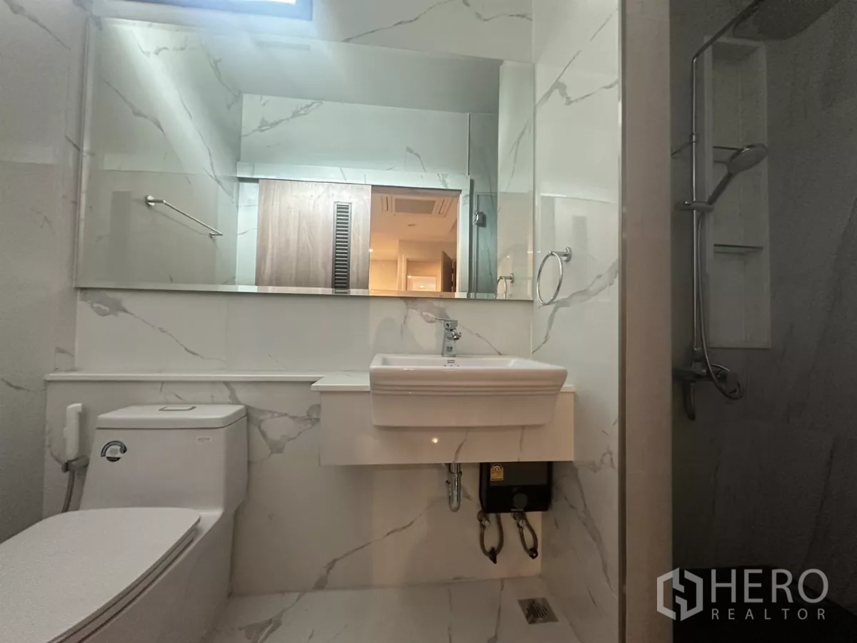 Townhouse for rent in Watthana, Bangkok - Bathroom with walk-in shower, marble walls and full-width mirror.