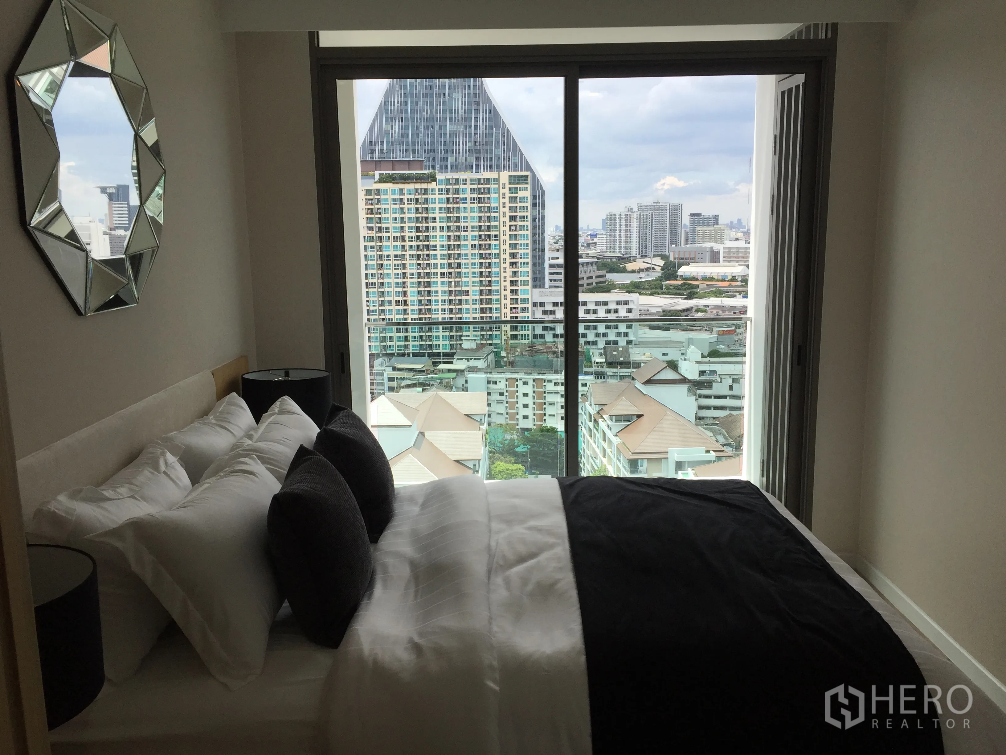 公寓 出售在Bang Rak, Bangkok - 卧室配几何装饰镜，大窗框出曼谷天际线。