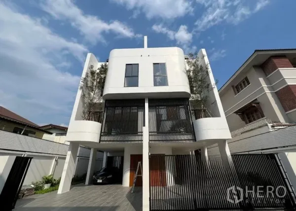 สำนักงานที่บ้าน ขายในPhra Khanong, Bangkok - โฮมออฟฟิศสามชั้นสไตล์โมเดิร์น พร้อมประตูรั้วและที่จอดรถในร่มใต้ตัวอาคารยื่นลอย.