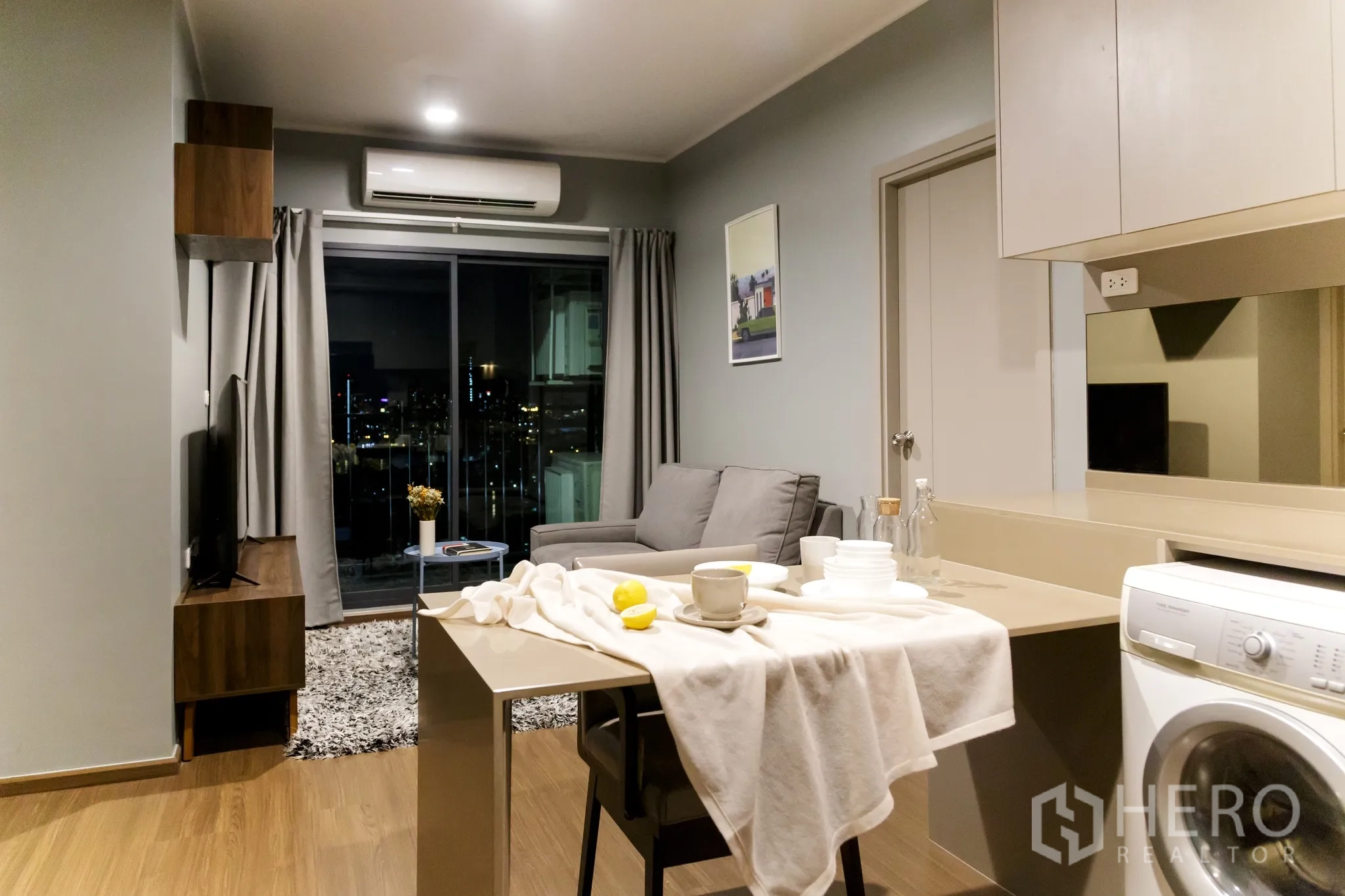 คอนโด for rent in Phra Khanong, Bangkok - พื้นที่นั่งเล่นเชื่อมครัว ประตูกระจกบานเลื่อนและวิวเมืองยามค่ำ