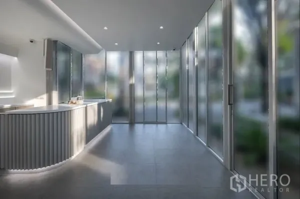 พื้นที่ขายปลีก ให้เช่าในKhlong Toei, Bangkok - ภายในร้านสว่างสไตล์โมเดิร์น เคาน์เตอร์โค้ง กระจกสูงจรดเพดาน และพื้นกระเบื้องสีเทา