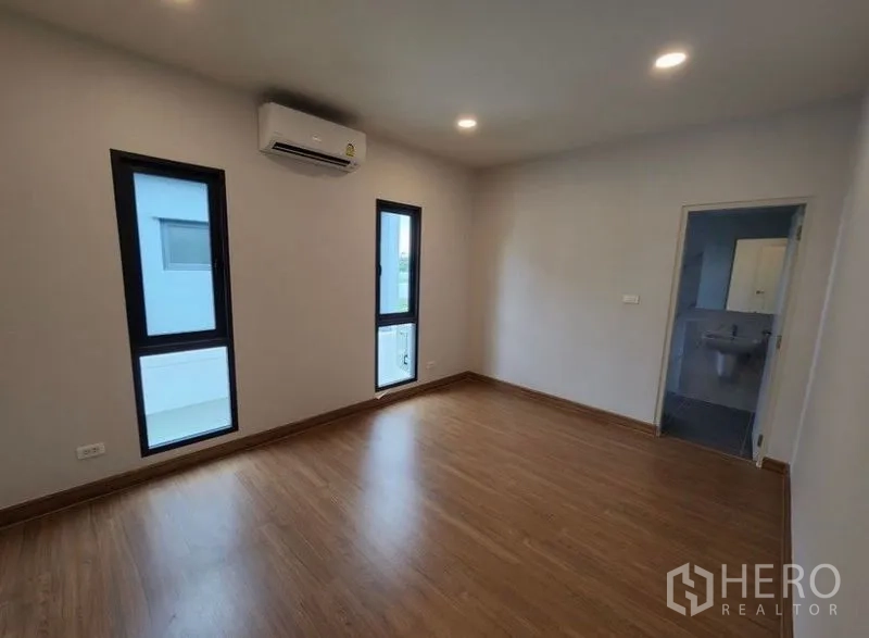 Detached House for rent in Bang Phli, Samut Prakan - Spacious bedroom with wood floor, recessed lights, air conditioner and ensuite bathroom.
