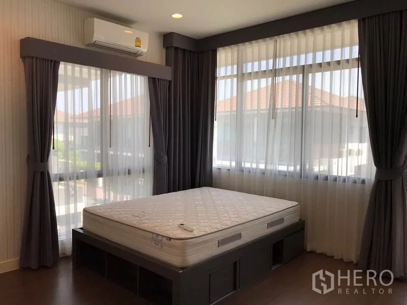 独立式住宅 出租在Bang Kapi, Bangkok - 转角卧室三面采光，厚窗帘与带收纳的床体。