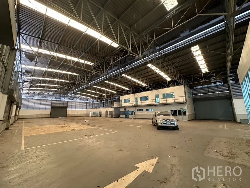 Showroom for rent or sale in Lam Luk Ka, Pathum Thani - Warehouse hall showing high steel roof and mezzanine offices.