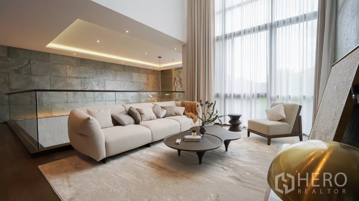 独立式住宅 出租或出售在Bang Kapi, Bangkok - 二层家庭厅，柔软沙发与茶几，配纱帘采光。