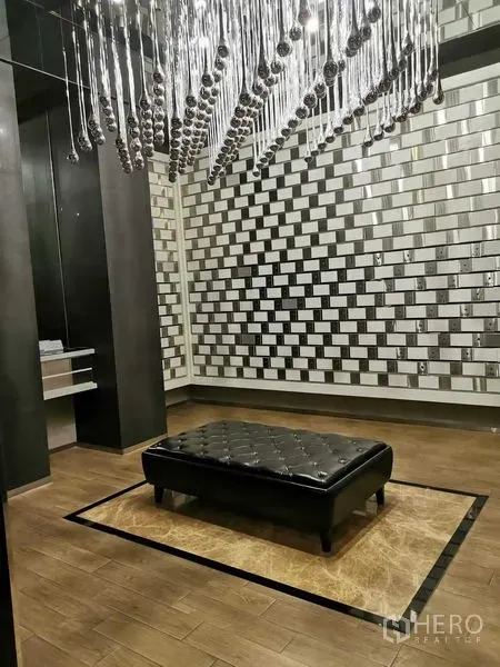 คอนโด ให้เช่า - มุมเลานจ์ในล็อบบี้สไตล์โมเดิร์น ผนังลายกระจกและโคมระย้า พร้อมเบาะหนัง