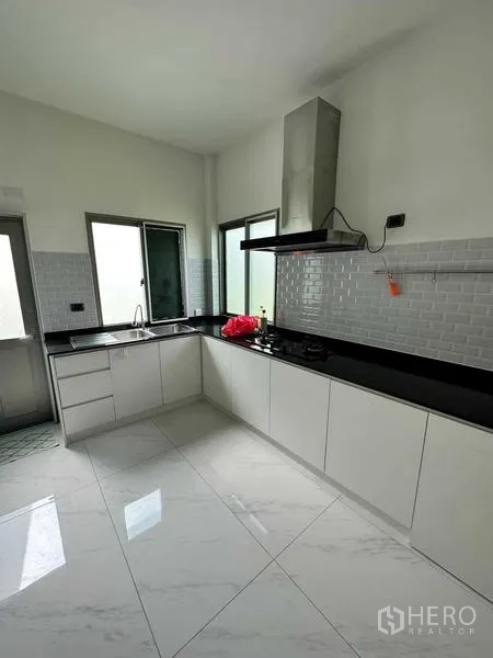 บ้าน ให้เช่าในLat Krabang, Bangkok - ครัวสไตล์โมเดิร์น ตู้สีขาว ท็อปหินสีดำ เครื่องดูดควัน และพื้นกระเบื้อง