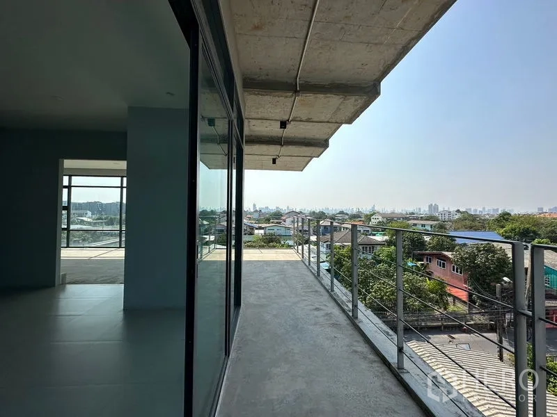 Home Office for rent or sale in Prawet, Bangkok - Balcony terrace with metal railing and skyline views beside sliding glass doors.