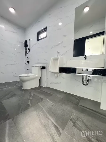 货栈 出售在Lam Luk Ka, Pathum Thani - 现代化卫浴，配坐便器、小便斗、洗手台与大理石纹墙面。