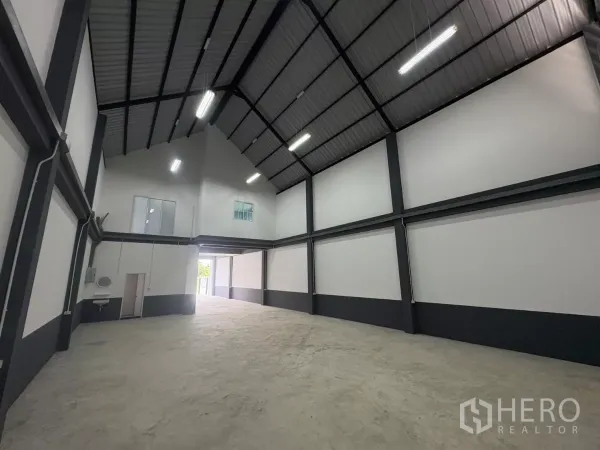 工厂 出租或出售在Bang Bua Thong, Nonthaburi - 仓库内部挑高，带夹层窗、洗手池与卫生间入口。