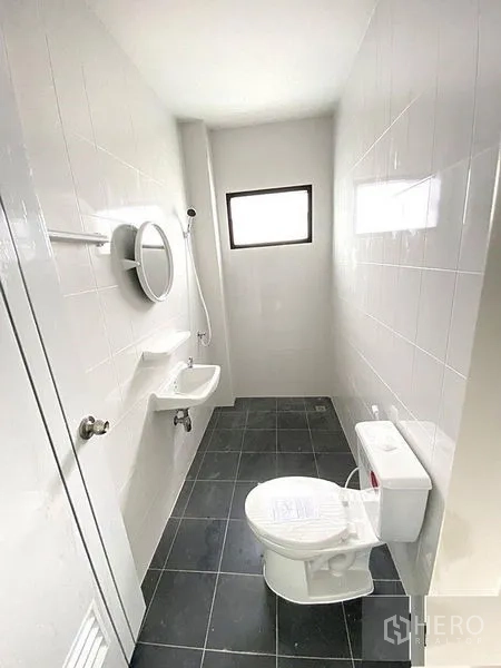 工厂 出租在Bang Bua Thong, Nonthaburi - 整洁的瓷砖浴室，带淋浴、座厕和小窗。