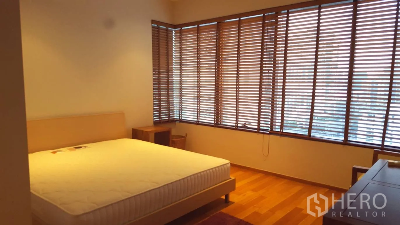 公寓 出租或出售在Khlong Toei, Bangkok - 主卧带转角落地窗、木百叶，特大床与床头柜。