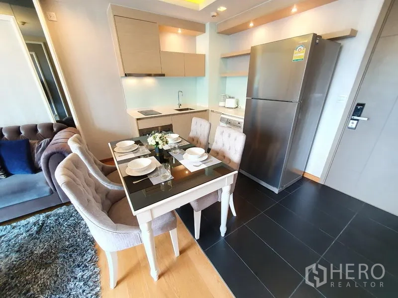 公寓 出租在Watthana, Bangkok - 现代小厨房，配不锈钢冰箱、洗衣机与四人餐桌。