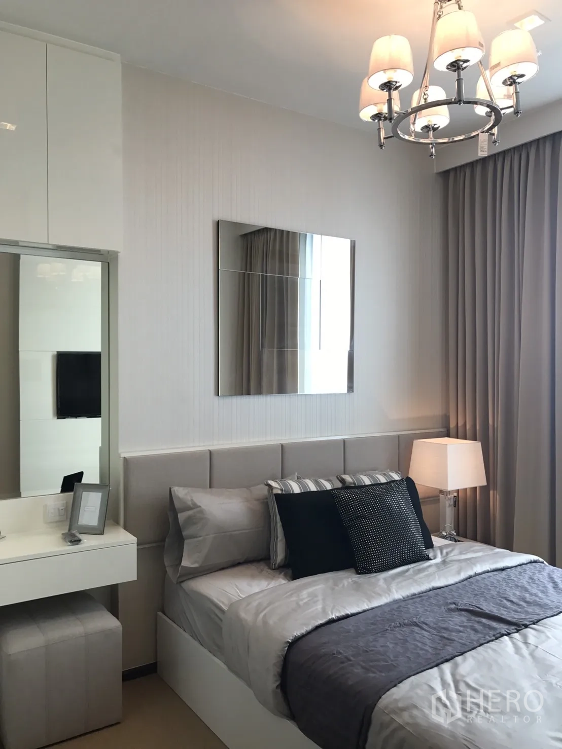 คอนโด ให้เช่าหรือขายในWatthana, Bangkok - ห้องนอนสว่างพร้อมหัวเตียงบุผ้า ชุดเครื่องนอนโทนเทา โคมระย้า และโต๊ะเครื่องแป้ง