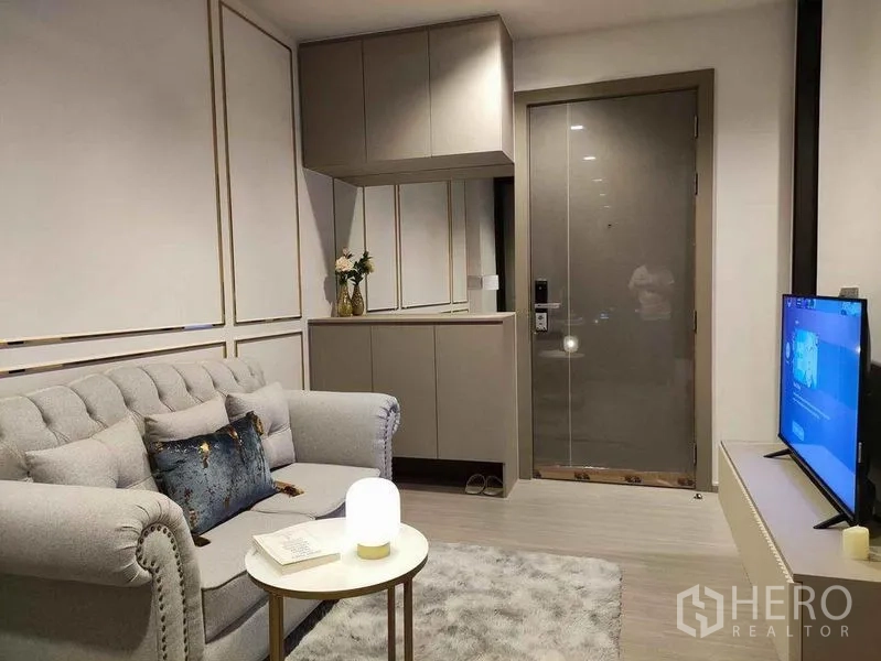 公寓 出租在Ratchathewi, Bangkok - 现代客厅，灰色沙发、内置柜与电视机组合。