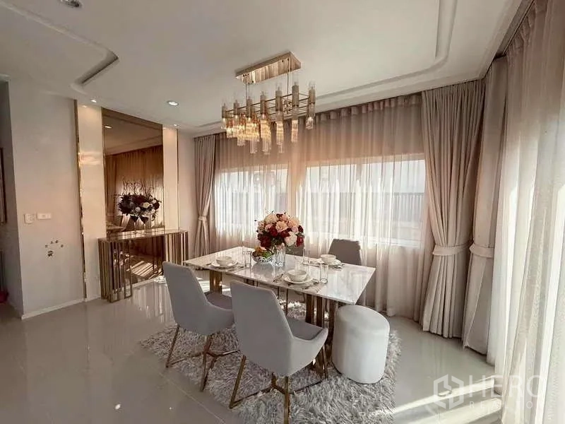 独立式住宅 出售在Bang Khen, Bangkok - 餐区设大理石餐桌、灰色软包餐椅与水晶吊灯。